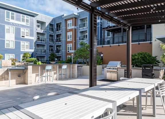 A patio with a table and chairs is surrounded by apartment buildings.