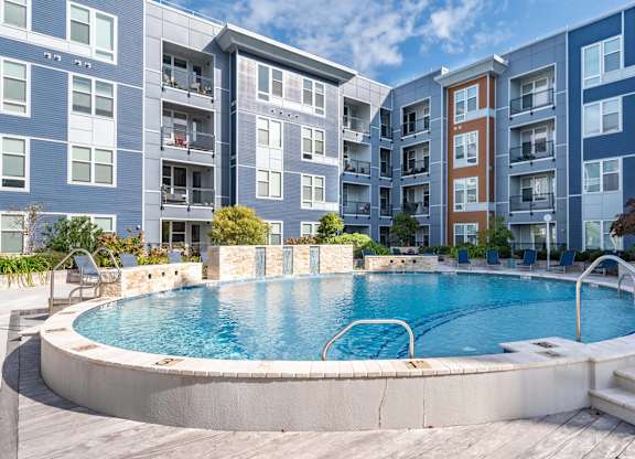 A swimming pool in front of apartment buildings.