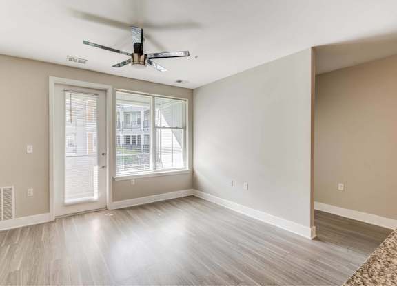 A room with a ceiling fan and a sliding glass door.