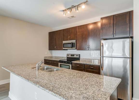 A kitchen with granite countertops and stainless steel appliances.