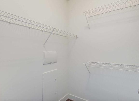 A white wall with a metal rack and a white door.
