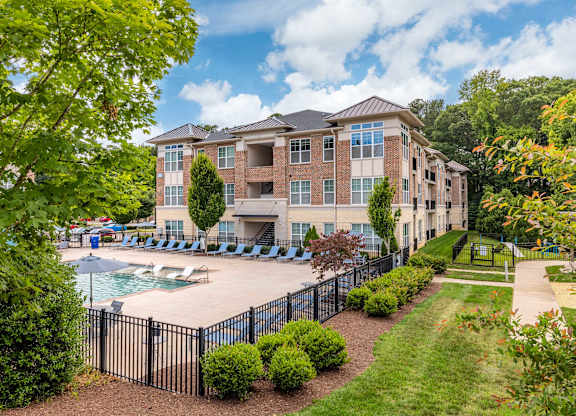 A large building with a pool in front of it at 1701 North Apartment Homes Apartments, Chapel Hill, North Carolina
