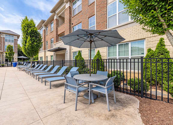 A row of chairs and tables are set up on a patio at 1701 North Apartment Homes Apartments, Chapel Hill, NC, 27514