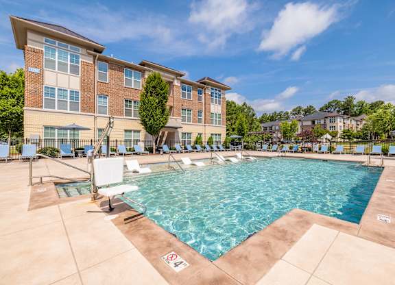 A large swimming pool in front of a multi-story apartment building at 1701 North Apartment Homes Apartments, Chapel Hill