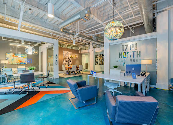 A modern office space with a glass wall and a hanging light fixture at 1701 North Apartment Homes Apartments, Chapel Hill