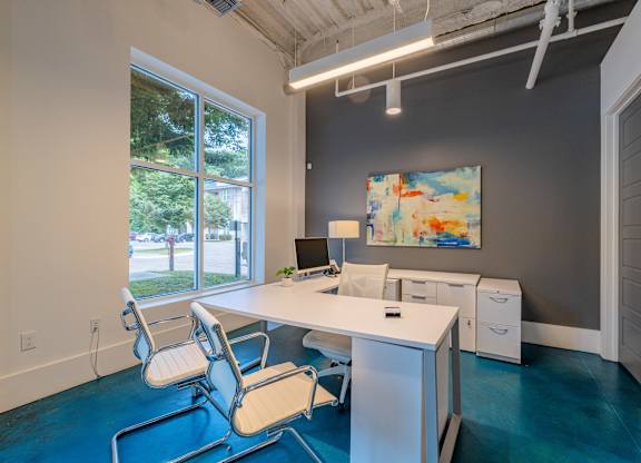 A room with a desk and chairs with a painting on the wall at 1701 North Apartment Homes Apartments, Chapel Hill, North Carolina
