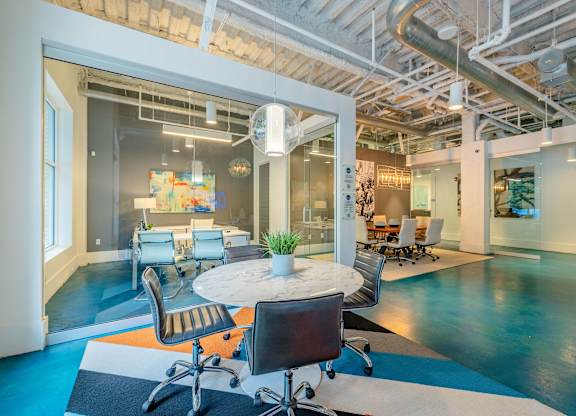 A modern office space with a glass table surrounded by chairs at 1701 North Apartment Homes Apartments, Chapel Hill