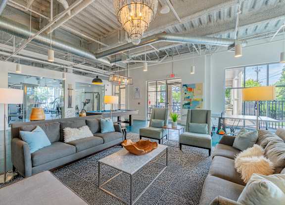 A spacious living room with a grey sofa set and a large coffee table at 1701 North Apartment Homes Apartments, Chapel Hill, 27514