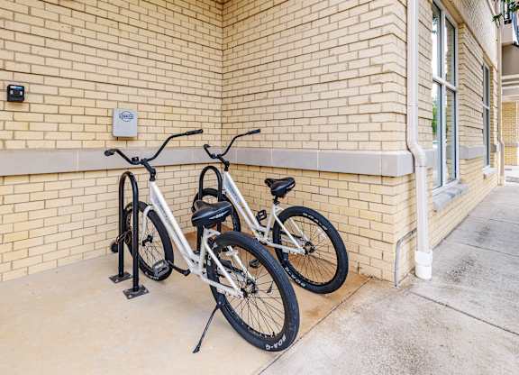 Two bicycles are parked next to a brick wall at 1701 North Apartment Homes Apartments, Chapel Hill, NC, 27514