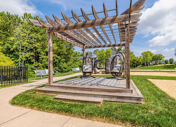 A wooden pergola structure with a metal sculpture in the middle at 1701 North Apartment Homes Apartments, Chapel Hill
