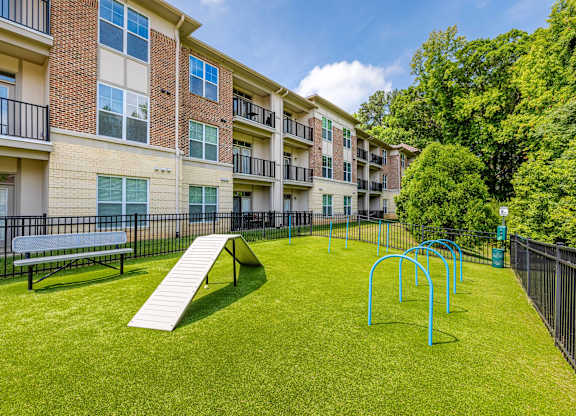A playground with a slide and monkey bars in front of apartment buildings at 1701 North Apartment Homes Apartments, Chapel Hill, NC, 27514
