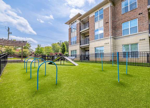 A playground area in front of a multi-story apartment building at 1701 North Apartment Homes Apartments, North Carolina, 27514