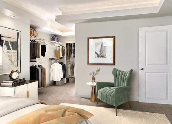 A bedroom with a green chair and a white door.