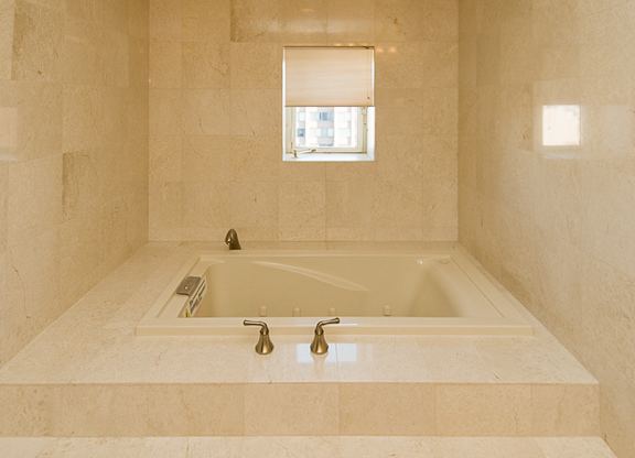 A bathroom with a tub and a window.