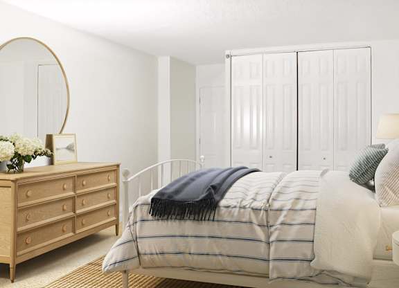A bedroom with a bed, a dresser, and a wardrobe.