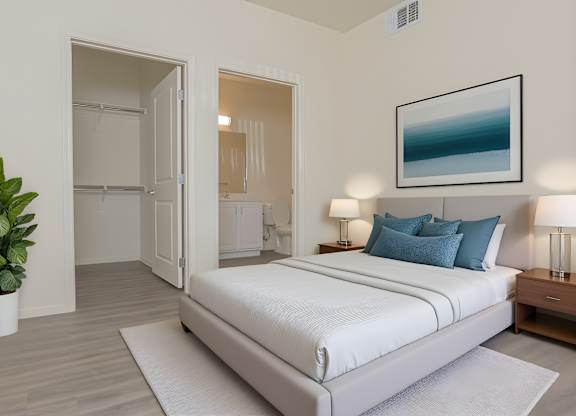 A bedroom with a large bed and a potted plant.