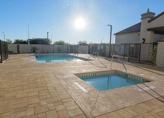 A sunny day at the pool with a fence surrounding the area.