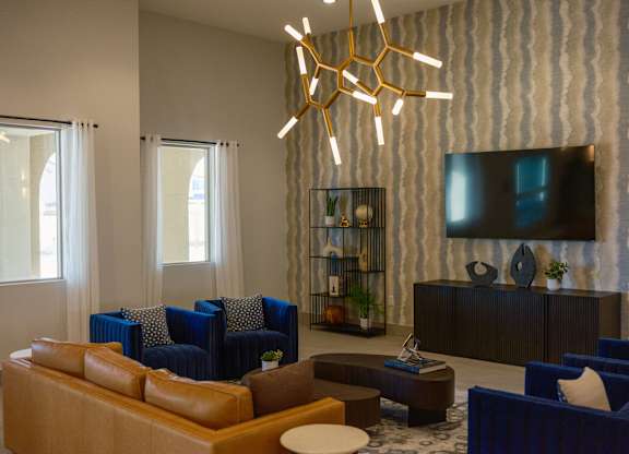 A modern living room with blue chairs and a wooden coffee table.