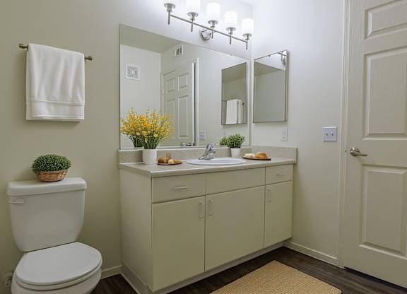 A white toilet sits next to a white sink in a bathroom.