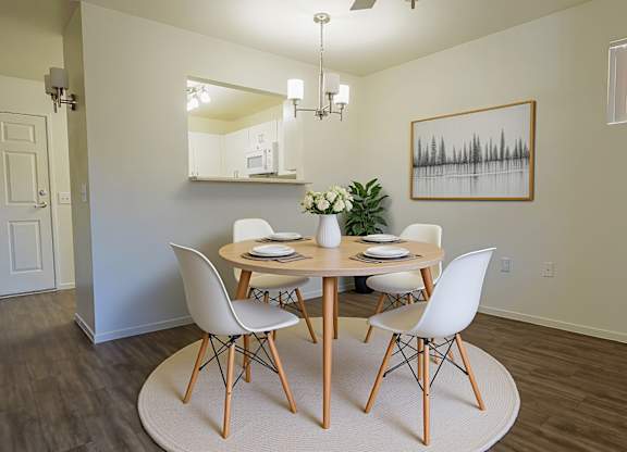 A dining room with a round table and chairs.