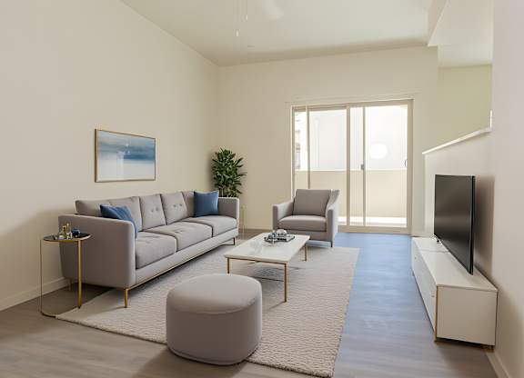 A living room with a grey sofa, a grey armchair, a grey ottoman, a coffee table, a flat screen TV, and a painting on the wall.