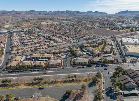 A bird's eye view of a residential area with houses, roads, and vehicles.