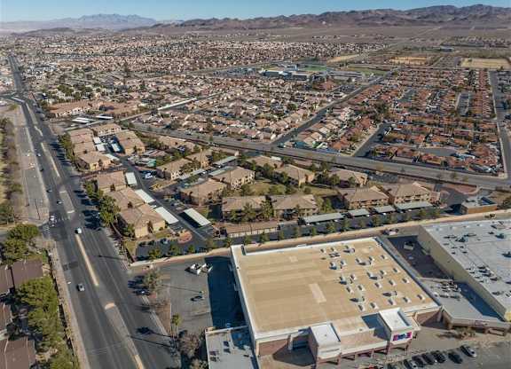 A large open parking lot is surrounded by apartment buildings.