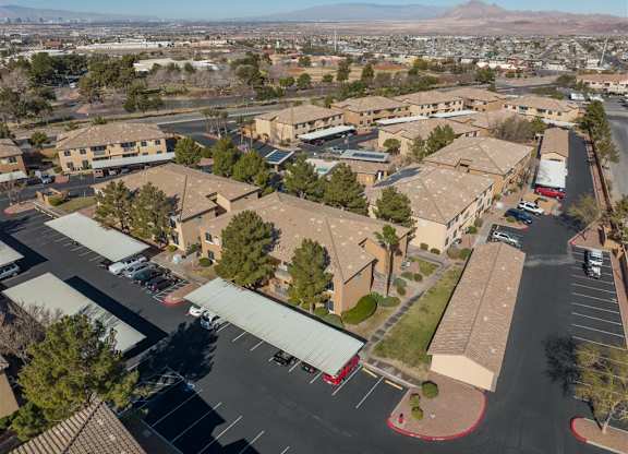 A parking lot is in front of a building with a mountain in the background.