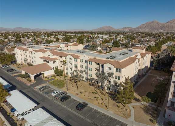 A large apartment complex with a parking lot in front.