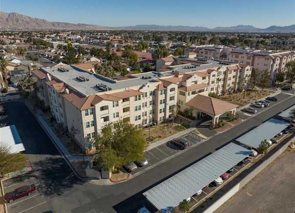 A large apartment complex with a parking lot in front.