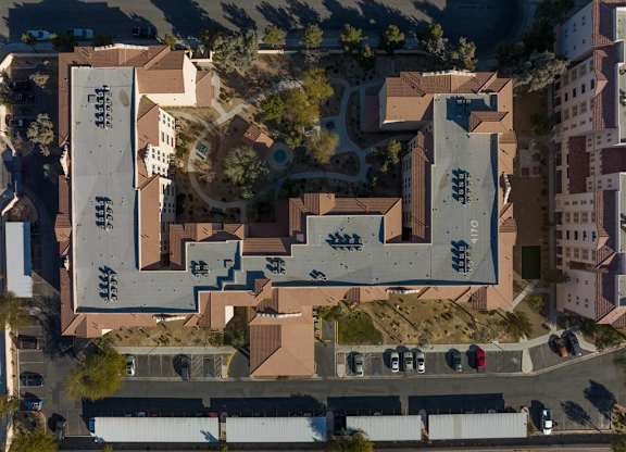 An aerial view of a large building with a parking lot in front.