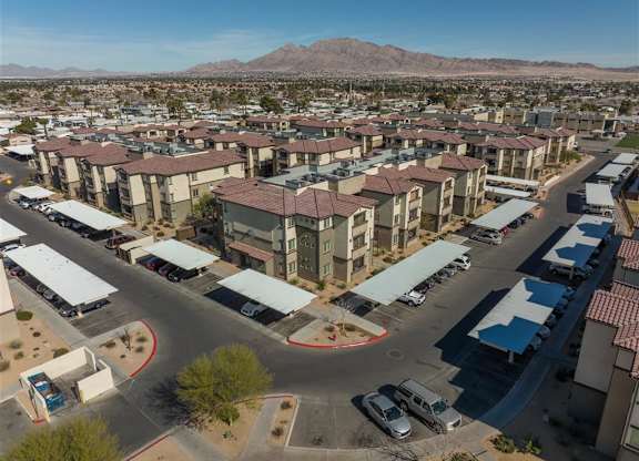 A large apartment complex with a parking lot in front.
