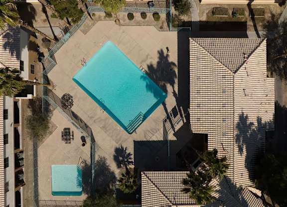 A swimming pool surrounded by a fence and trees.