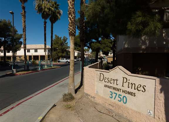 A sign for Desert Pines Apartment Homes 3750 is on a wall.