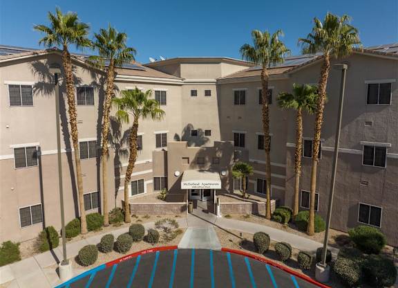 A building with palm trees in front of it.