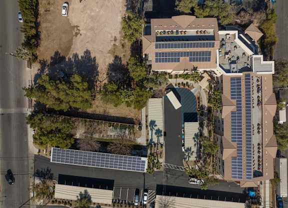 A building with a green roof and solar panels on the side.