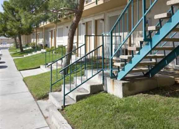 A tree is in front of a building with a blue staircase.