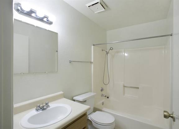 A white bathroom with a sink, toilet, and bathtub.