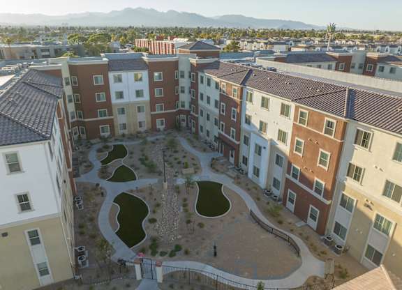 A courtyard surrounded by apartment buildings with a mountain in the background.