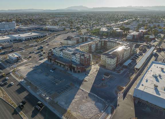 A parking lot is in the foreground of a city scene.
