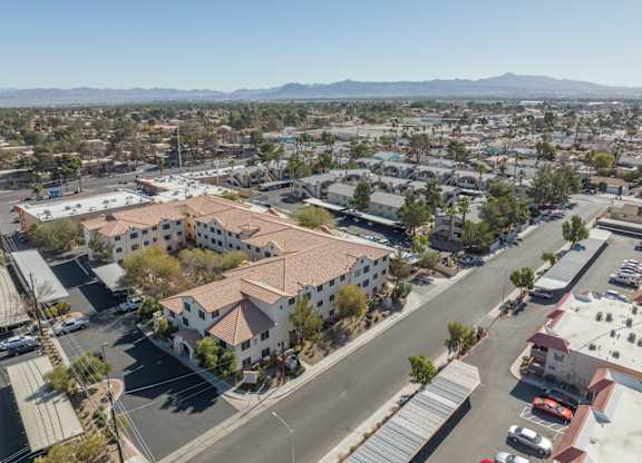 A bird's eye view of a town with a large white building with a red roof in the center.