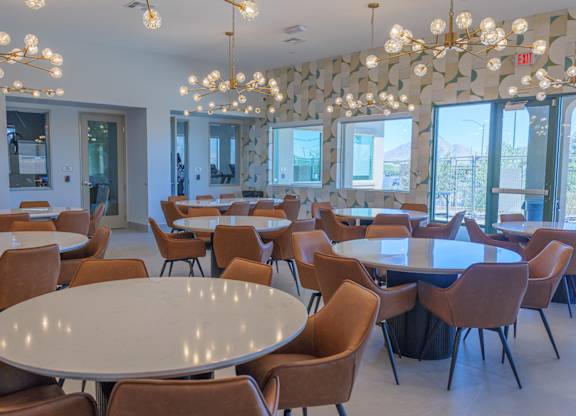 A room with tables and chairs and a chandelier.