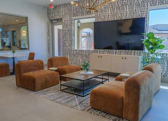 A living room with a large television and a patterned wall.