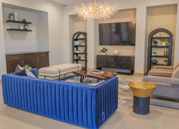 A living room with a blue couch and a chandelier.