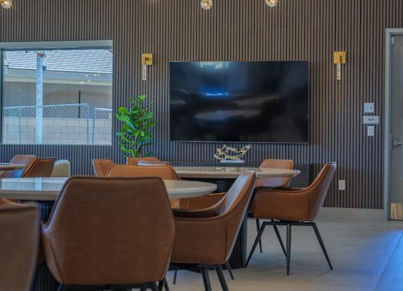 A modern dining room with a large screen tv mounted on the wall.