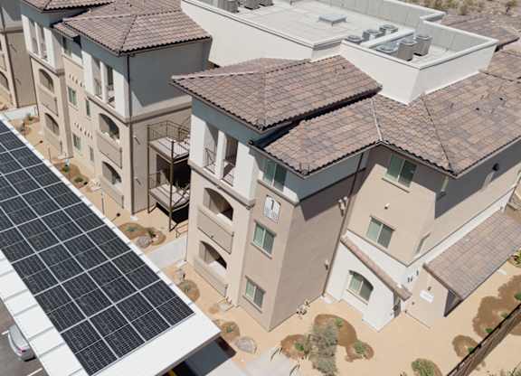 A long row of solar panels are installed on the roof of a parking lot.