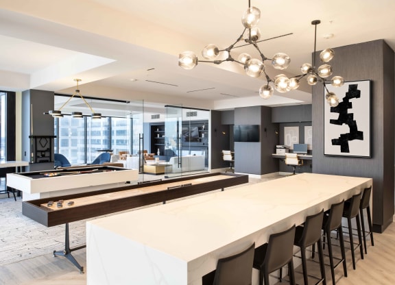 a communal table with a shuffleboard and foosball table at 220 Meridian, Indianapolis, IN 46204
