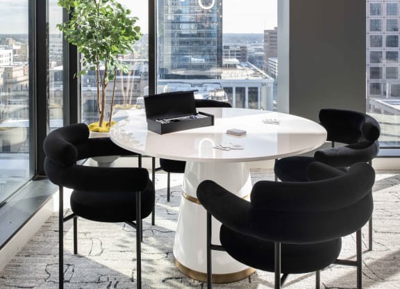 a round white table with black chairs in a room with floor to ceiling windows  at 220 Meridian, Indianapolis, IN, 46204