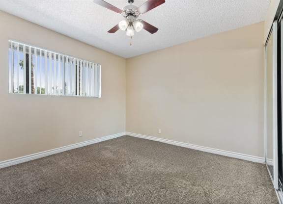an empty living room with a ceiling fan and a window at Terramonte Apartment Homes, Pomona, CA, 91767