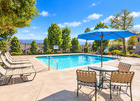A pool area with chairs and tables is shown.
